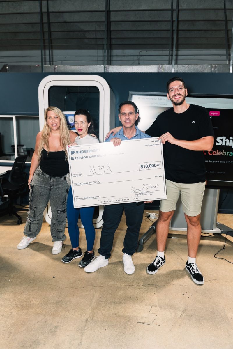 Team ALMA holding an oversized Superteam USA check for $10,000 at Cursor Miami Ship Night